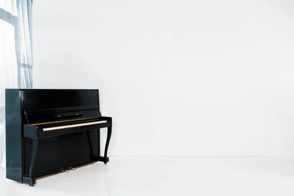 Pianoforte nero su sfondo bianco con spazio di copia — Foto stock