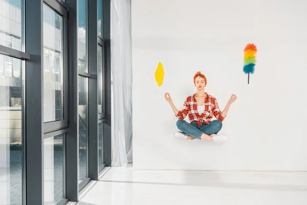 Floating girl in jeans and plaid shirt meditating with rag and duster on white background — Stock Photo