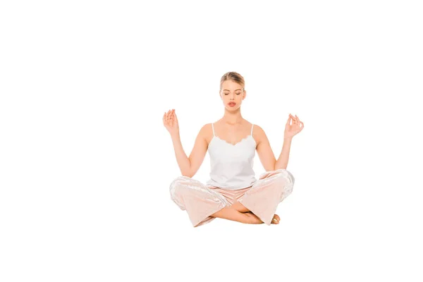 Chica en pijama meditando en el aire aislado en blanco - foto de stock