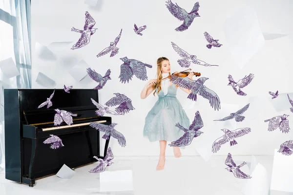 Chica flotante en vestido azul tocando el violín con ilustración de aves - foto de stock