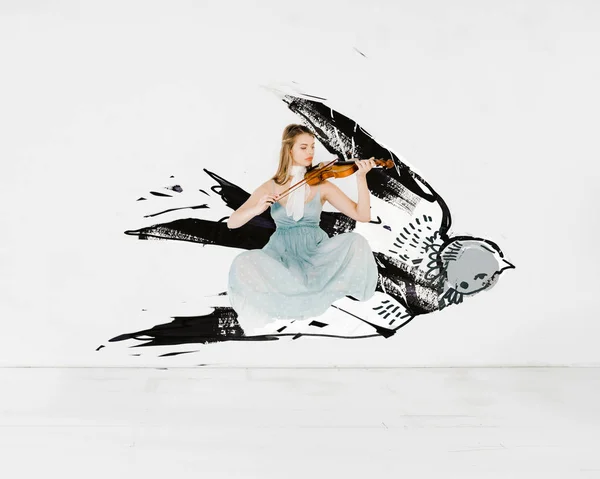Плаваюча дівчина в блакитній сукні грає на скрипці з ілюстрацією птахів — стокове фото