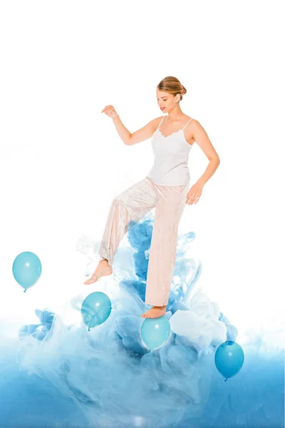 Girl in pyjamas standing on blue ballons with cloud illustration — Stock Photo
