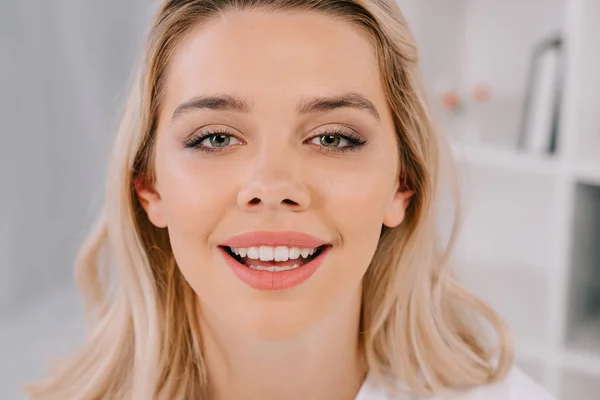 Hermosa mujer rubia con sonrisa de dientes mirando a la cámara - foto de stock