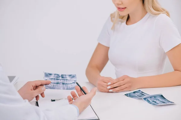 Visión parcial de la mujer durante la consulta con ortodoncista aislado en blanco - foto de stock