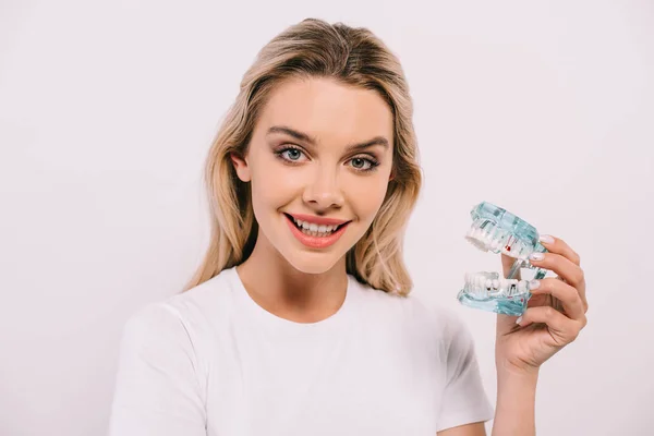 Beautiful smiling woman looking at camera while holding jaw model isolated on white — Stock Photo