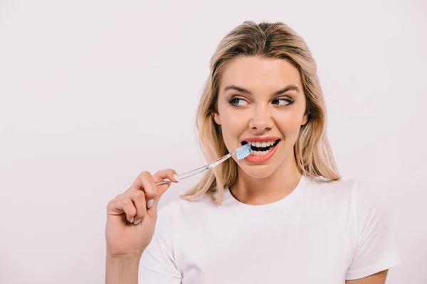 Beautiful woman in white t-shirt brushing teeth isolated on white — Stock Photo