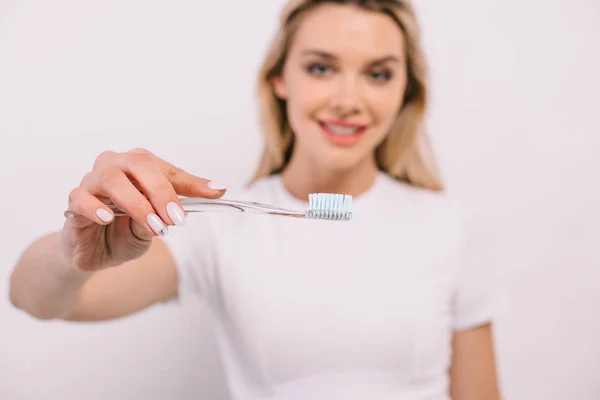 Enfoque selectivo del cepillo de dientes con la mujer en el fondo aislado en blanco - foto de stock