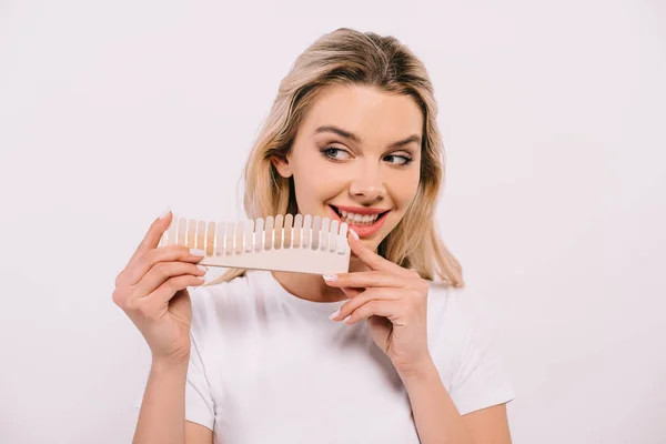 Bela mulher sorridente segurando dentes paleta de cores isoladas em branco, dentes branqueamento conceito — Fotografia de Stock