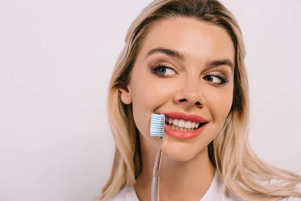 Belle femme souriante tenant brosse à dents isolée sur blanc avec espace de copie — Photo de stock