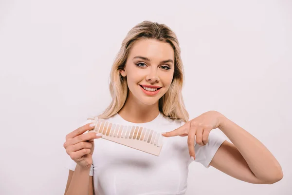 Beautiful woman pointing with finger at teeth color palette isolated on white, teeth whitening concept — Stock Photo