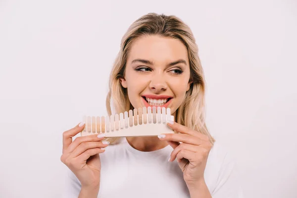 Bella donna sorridente che tiene i denti tavolozza dei colori isolati su bianco, concetto di sbiancamento dei denti — Foto stock