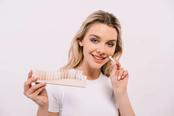 Schöne Frau schaut in die Kamera und hält Zähne Farbpalette isoliert auf weiß, Zahnweiß-Konzept — Stockfoto