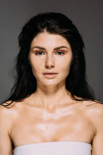 Attractive brunette girl with freckles on face isolated on grey — Stock Photo