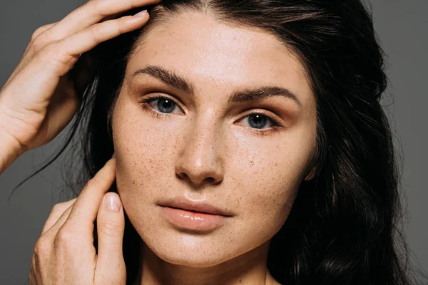 Portrait de jolie fille avec des taches de rousseur sur le visage isolé sur gris — Photo de stock