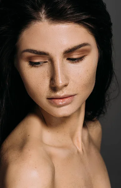 Hermosa mujer tierna con pecas en la cara aislada en gris - foto de stock