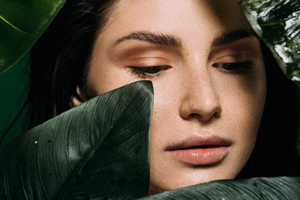 Tenera giovane donna con lentiggini in posa con foglie verdi — Foto stock