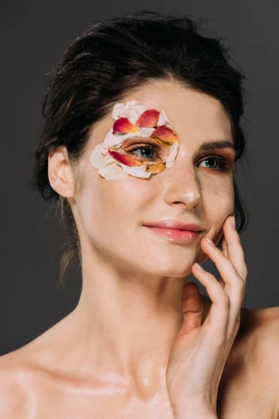 Bela mulher sorridente com pétalas florais em torno do olho isolado em cinza — Fotografia de Stock