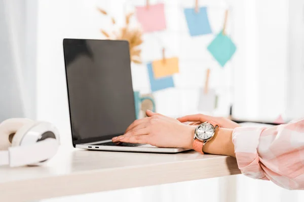 Vista parcial da mulher com relógio de pulso usando laptop com tela em branco — Fotografia de Stock