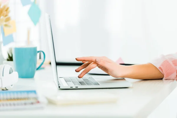 Partial view of woman typing on laptop keyboard at workplace — Stock Photo