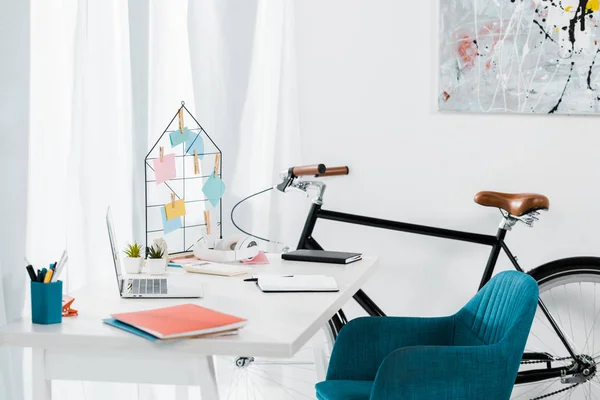 Уютный домашний офис с современной мебелью и черным велосипедом — стоковое фото