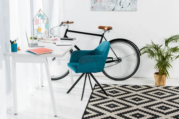 Escritório acolhedor em casa com móveis, grande planta e bicicleta — Fotografia de Stock