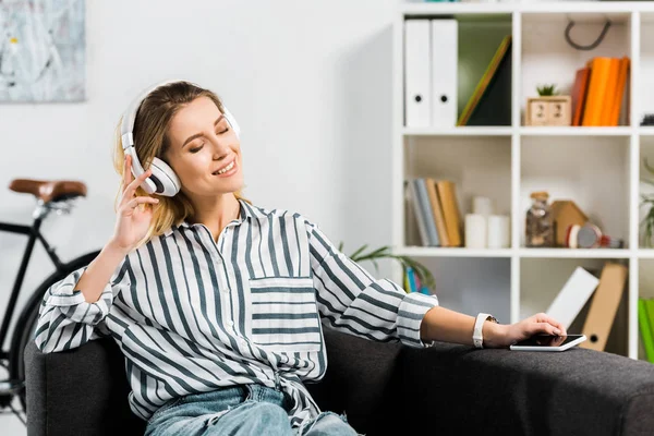 Splendida donna in camicia a righe ascoltare musica ad occhi chiusi — Foto stock