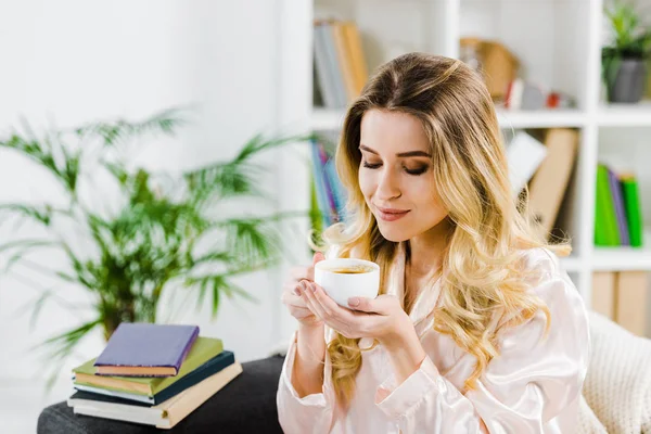 Wunderschöne lockige Frau im Pyjama, die morgens Kaffee trinkt — Stockfoto