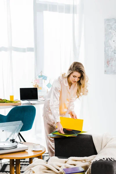 Attractive young woman in pyjamas holding vinyl record in morning — Stock Photo