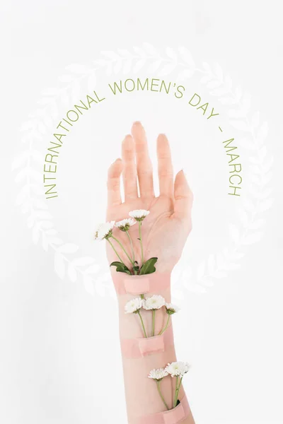 Cropped view of woman with wildflowers on hand on white background with international womens day illustration — Stock Photo