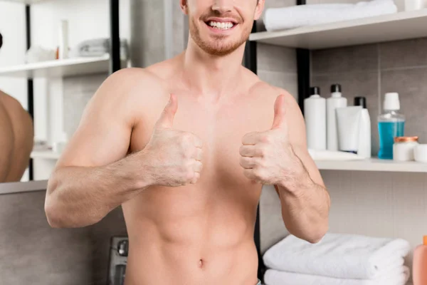 Ausgeschnittene Ansicht eines hemdlosen Mannes, der im Badezimmer die Daumen mit den Händen nach oben zeigt — Stockfoto