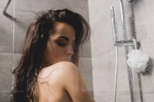 Brunette and naked woman taking shower in cabin — Stock Photo