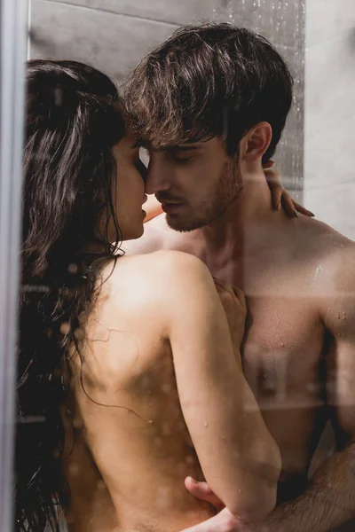 Bel homme et belle femme étreignant dans la cabine de douche — Photo de stock