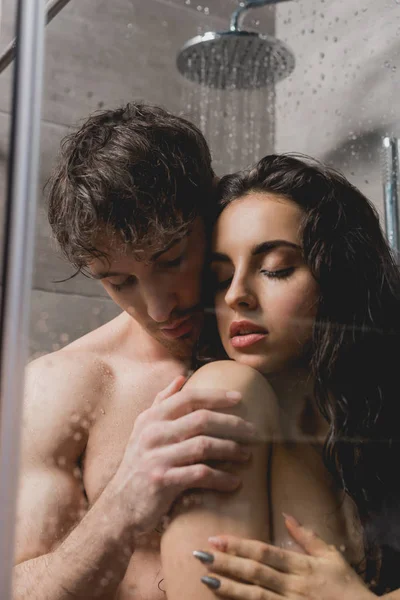 Handsome man and attractive woman hugging and taking shower in cabin — Stock Photo