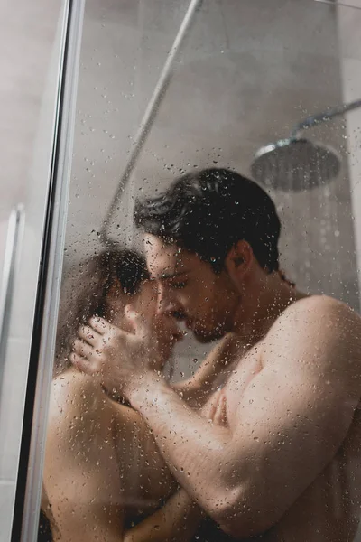 Enfoque selectivo de pareja sexy abrazo y tomar la ducha - foto de stock