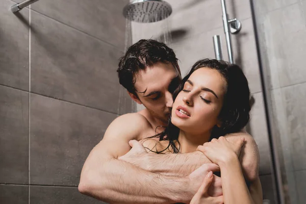 Naked man and attractive woman hugging in shower cabin — Stock Photo