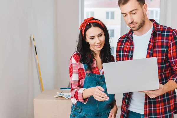 Donna attraente in piedi con il fidanzato e guardando il computer portatile — Foto stock