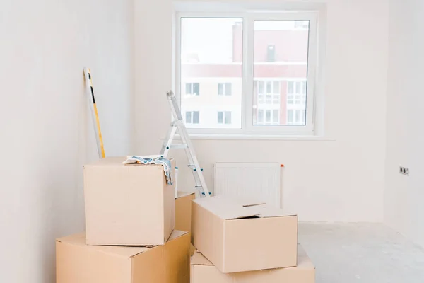 Chambre avec boîtes en carton et échelle métallique — Photo de stock