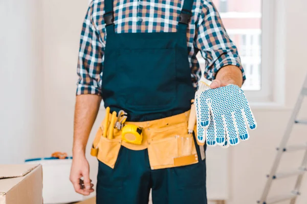 Vista recortada del manitas sosteniendo guantes en la mano - foto de stock