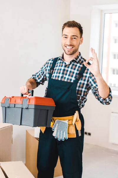 Manitas alegres sosteniendo caja de herramientas y mostrando signo ok - foto de stock