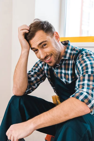 Alegre faz-tudo sorrindo enquanto olha para a câmera — Fotografia de Stock