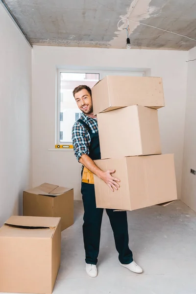 Щасливий майстер тримає коробки, стоячи в кімнаті — Stock Photo