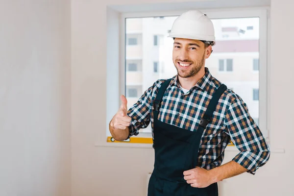 Feliz faz-tudo sorrindo enquanto de pé e mostrando o polegar para cima — Fotografia de Stock