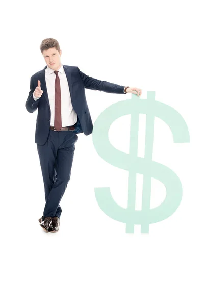 Successful young businessman with big dollar sign pointing at you isolated on white — Stock Photo
