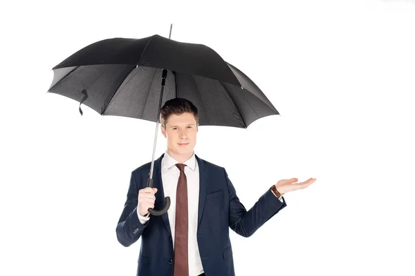 Guapo hombre de negocios con paraguas comprobando la lluvia, aislado en blanco - foto de stock