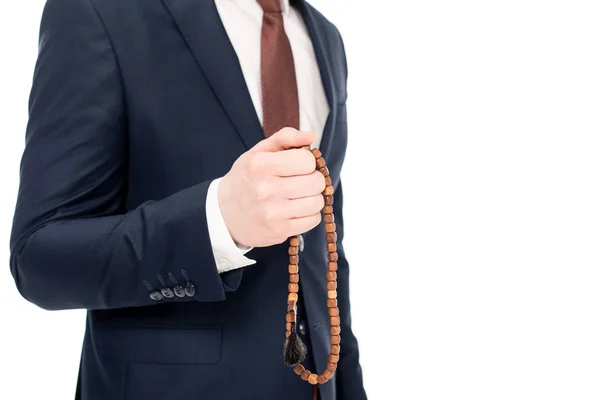 Vista recortada del hombre de negocios rezando y sosteniendo cuentas de rosario aisladas en blanco - foto de stock