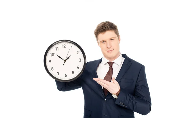 Guapo hombre de negocios sosteniendo reloj aislado en blanco - foto de stock