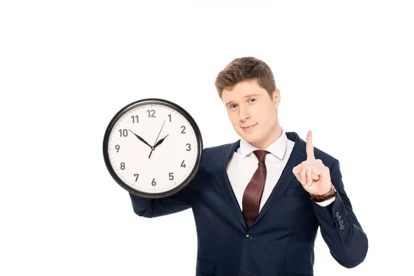 Handsome businessman having idea and pointing up while holding clock isolated on white — Stock Photo