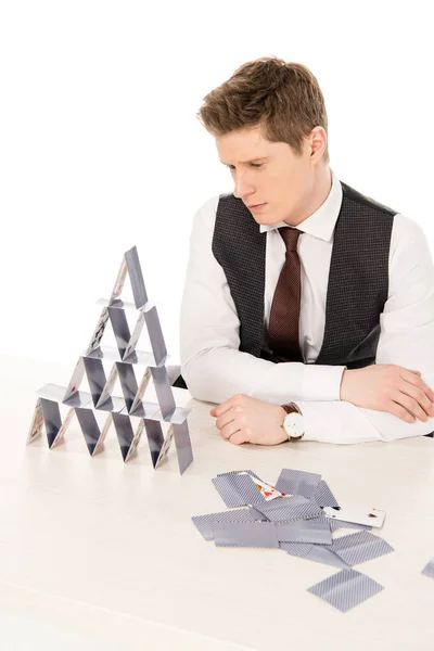 Bonito gerente concentrado fazendo pirâmide de jogar cartas isoladas em branco — Fotografia de Stock