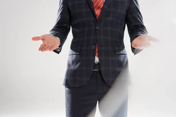 Cropped view of stylish businessman presenting something on grey — Stock Photo