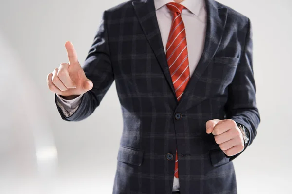 Cropped view of young businessman pointing on grey — Stock Photo